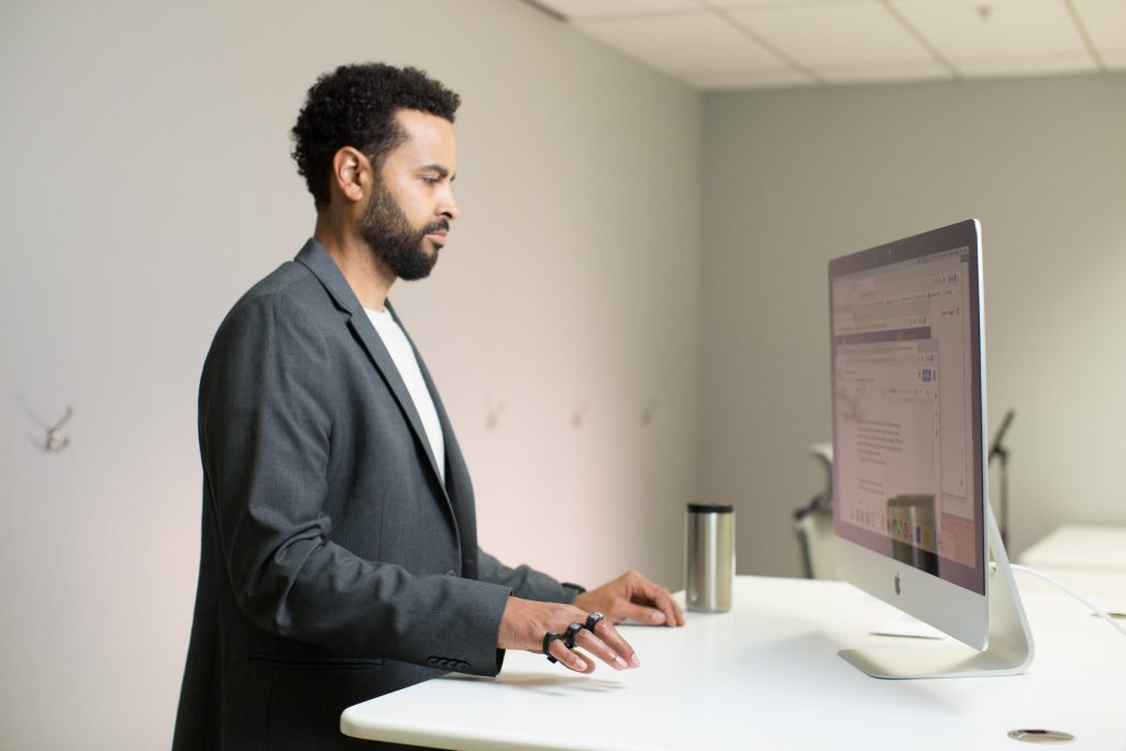 Man tapping at standing desk with perfect posture using Tap